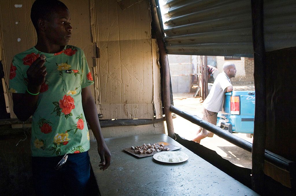 A young Entrepreneur sells meat from his makeshift kitchen in Soweto, South Africa