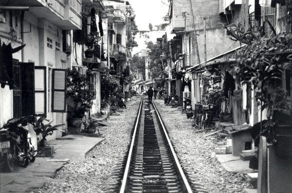 a lonely character walking along the railroad cutting through Hanoi, Vietnam (35mm film negative)